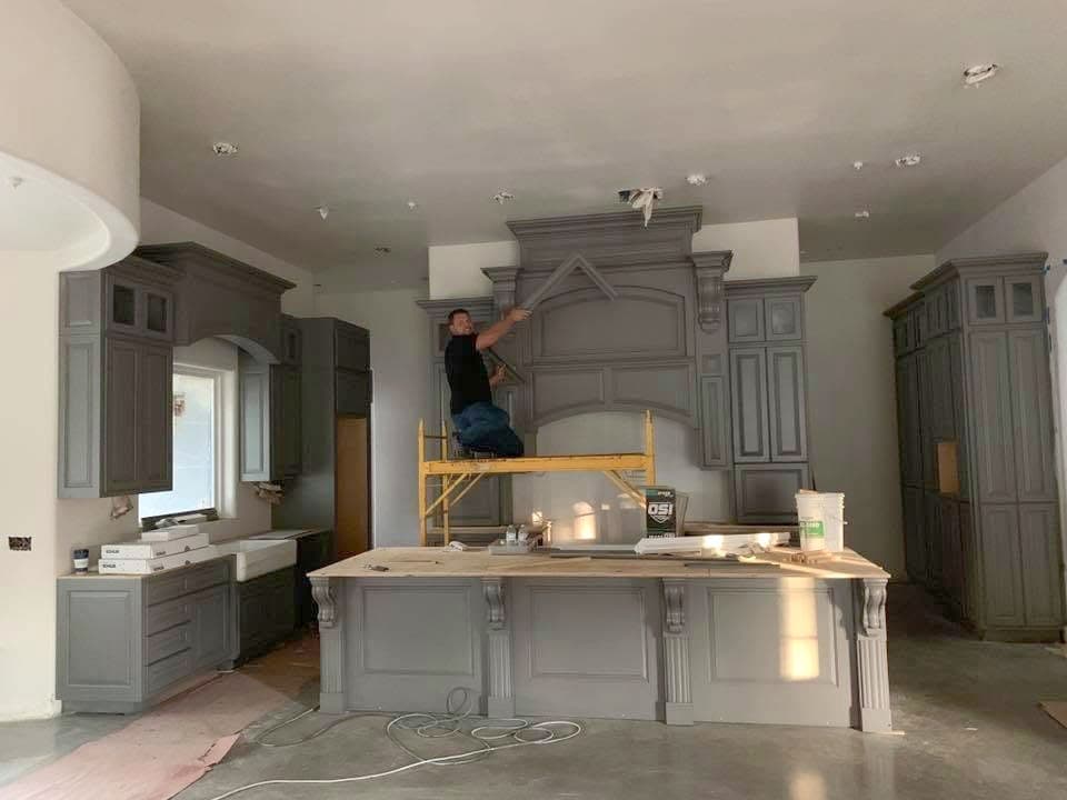 Andrey Voronenko on scaffolding, installing a custom hood surround during a kitchen build