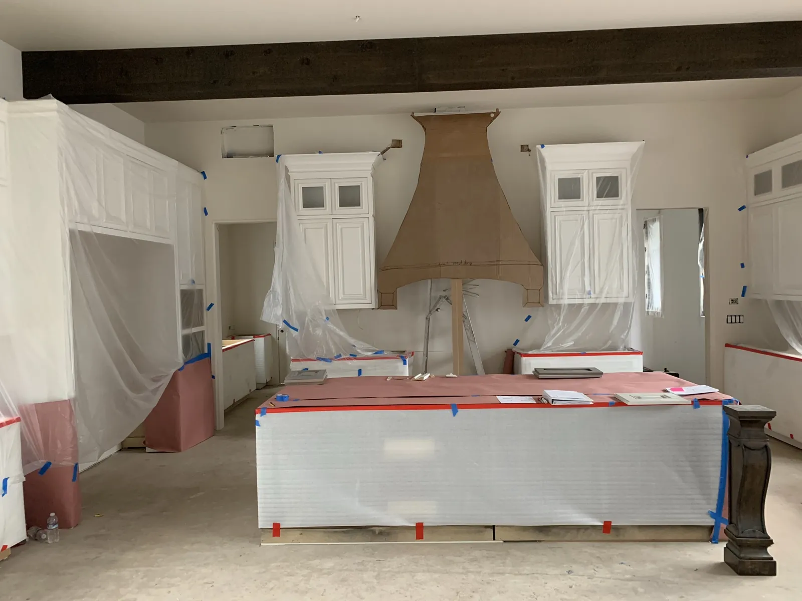Full-scale cardboard template of a custom range hood mocked up on site before the hood is built