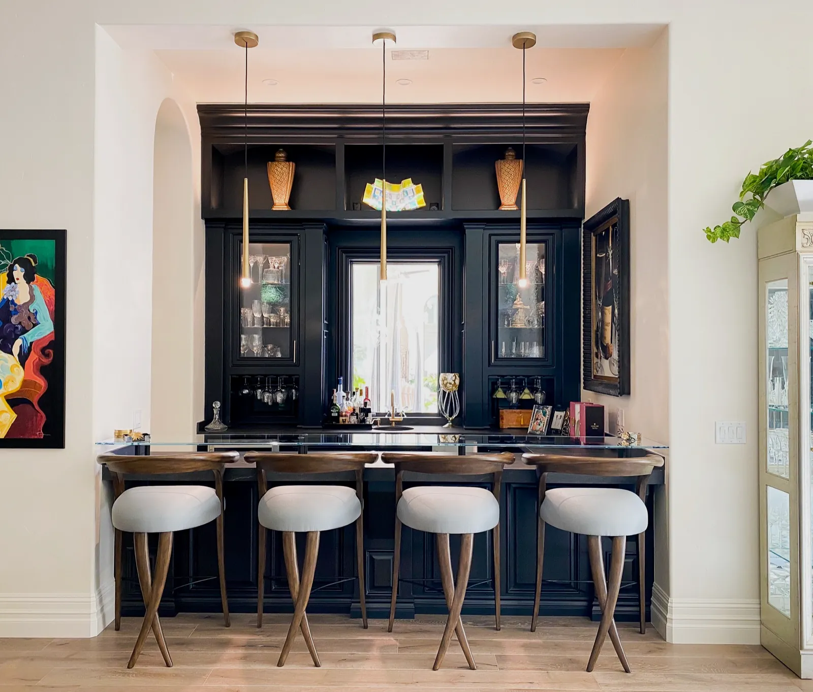 Black custom home bar with glass-front upper cabinets and a floating glass counter