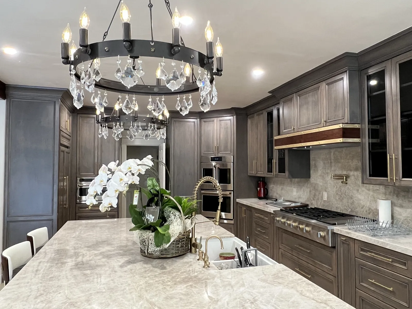 Estate kitchen with custom stained cabinetry and a brass-banded wood hood