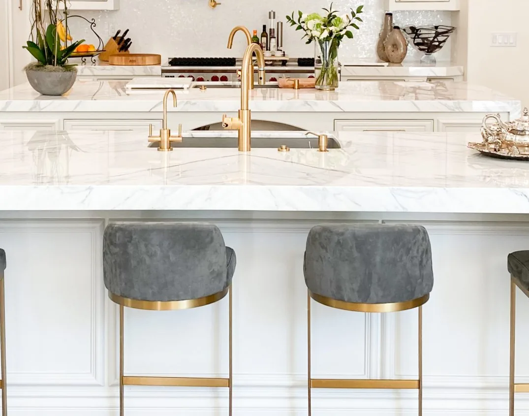 Custom island built to the room with a marble counter and integrated sink run