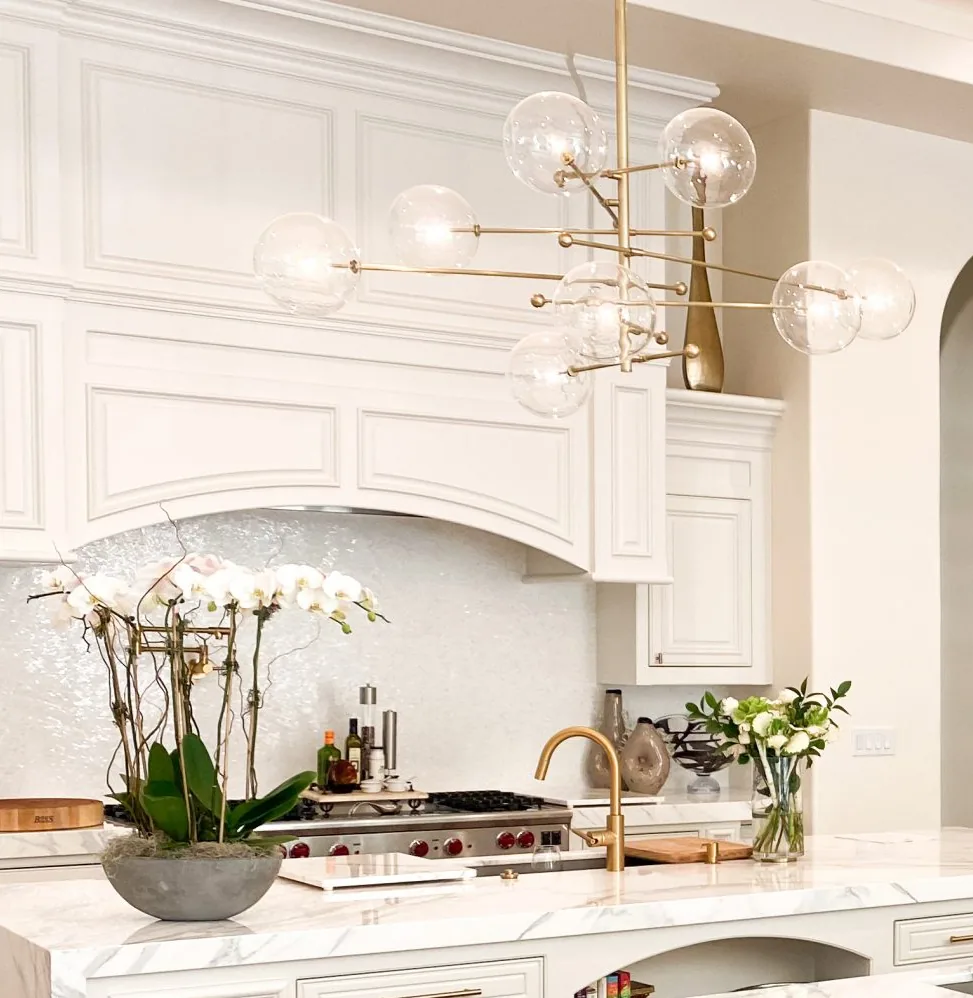 Painted full-height cabinetry with a paneled range hood and arched detail