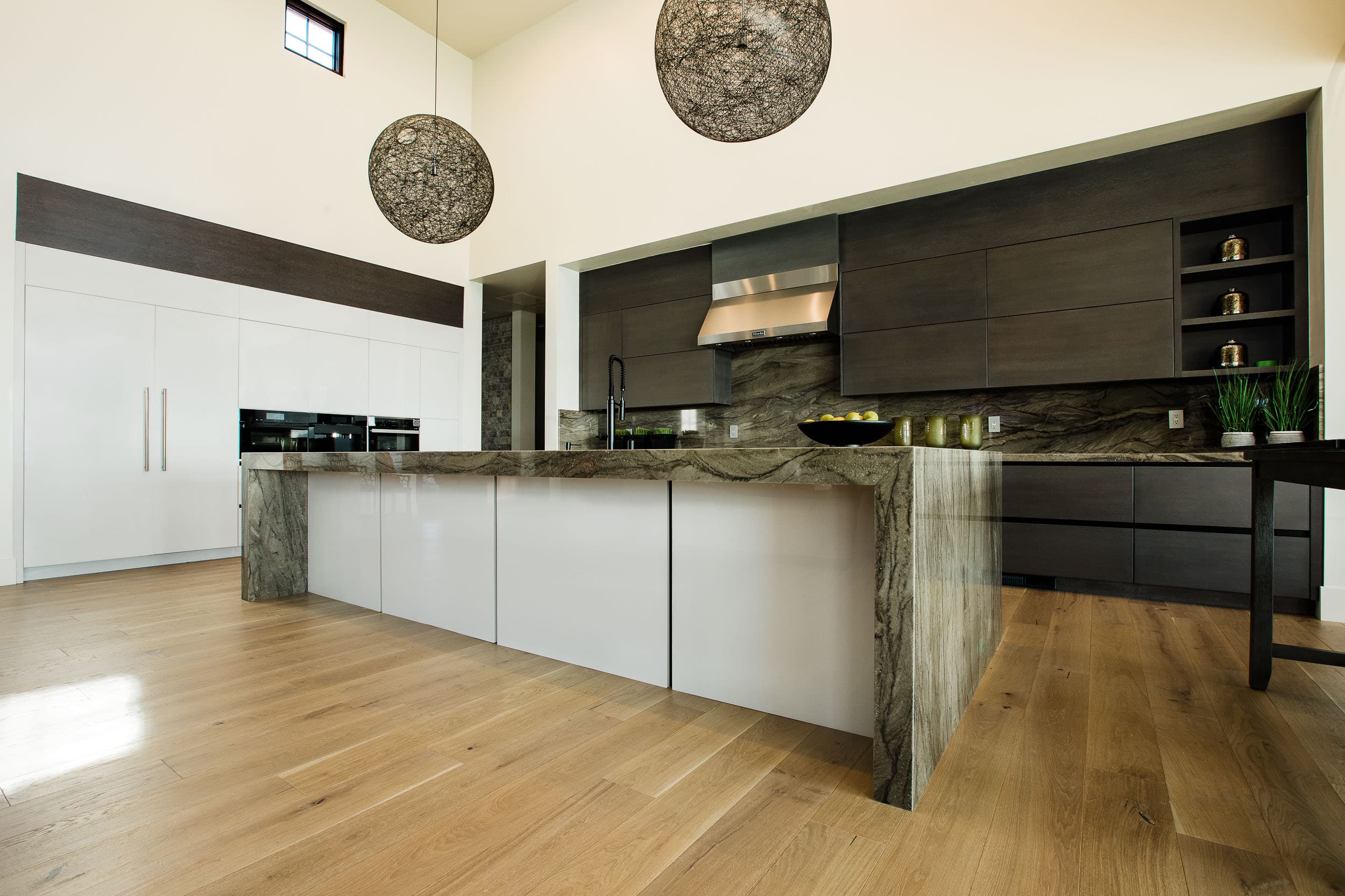Dark wood-tone uppers paired with light cabinetry in one kitchen by AV’s Cabinets